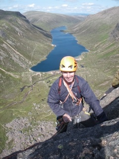 Kenny appearing into the sunshine at the top of the crag