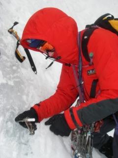 Placing an ice screw on a Winter Climbing Course