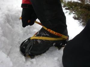 Kneeling to fasten crampons