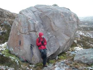Sheltering behind a large sandstone boulder